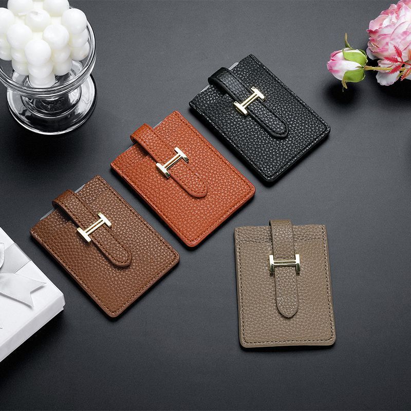 Black leather card holder with gold buckle on dark background

Minimalist leather wallet for men and women, slim design

Close-up of textured genuine leather card case with gold hardware

Stylish black credit card holder, front pocket wallet

Luxury leather accessory, compact and elegant card organizer

